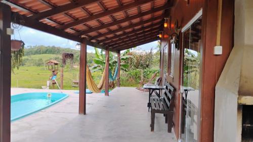 a patio with a hammock next to a pool at Casa Sítio Campo e Mar Balneário Picarras in Piçarras