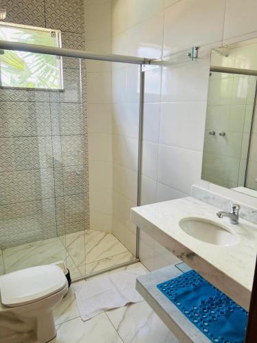 a bathroom with a shower and a toilet and a sink at Pousada Hilário ltda in São João del Rei
