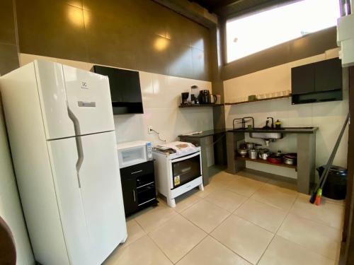 una cucina con un frigorifero bianco e una stufa di Hospedaria aconchego 4 a Garopaba