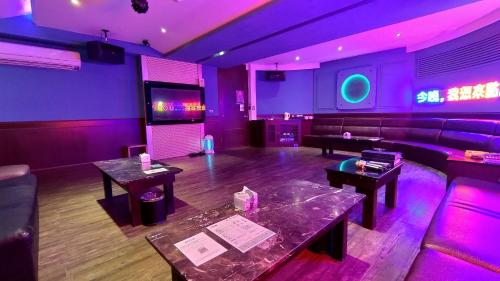 a room with purple lighting and tables and a stage at Vogue Boutique Motel in Yangmei