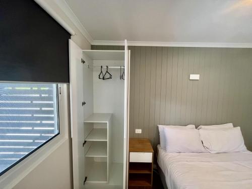 a small bedroom with a bed and a window at Young Caravan and Tourist Park in Young