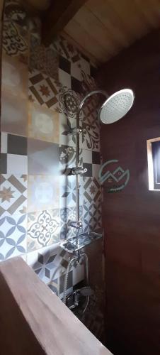 a shower in a bathroom with a tile wall at Cabañas Cerro de Piedra in Pucón