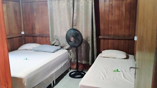 two beds in a room with wood paneling at Casa Sítio Campo e Mar Balneário Picarras in Piçarras