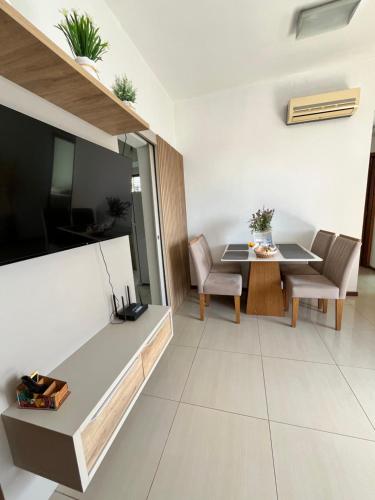 a living room with a table and a television at Apartamento em Manaus in Manaus