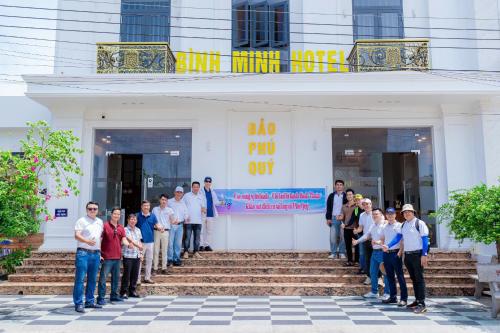 a group of people standing in front of a building at Khách Sạn Bình Minh-Đảo Phú Quý in Cu Lao Thu