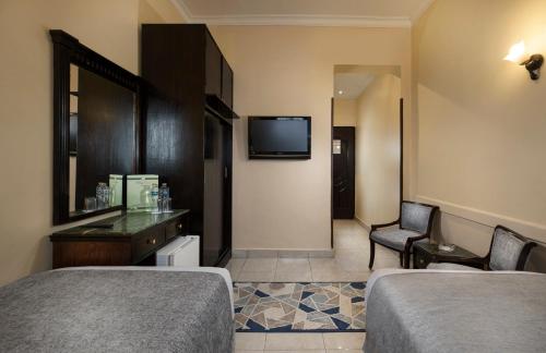 a hotel room with two beds and a television at Holidays Express Hotel in Cairo