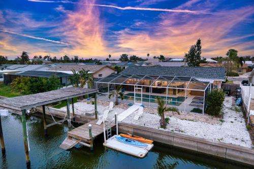 una casa con muelle y un barco en el agua en Private Dock Heated Pool Hot Tub Game Room Fun, en Apollo Beach