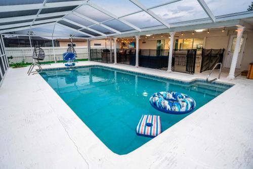 a swimming pool with two chairs and a swimming poolvisor at Private Dock Heated Pool Hot Tub Game Room Fun in Apollo Beach
