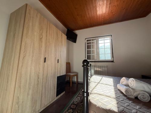 a bedroom with a bed and a large wooden cabinet at Moradia do Pátio in Arcos de Valdevez