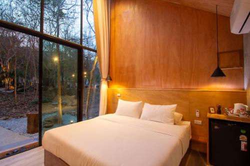 a bedroom with a bed and a large window at Issara Bar&House in Ko Larn