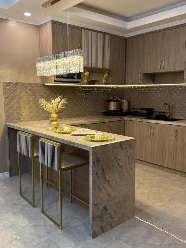 a kitchen with a large marble island with chairs at City View at The Gramercy Residences in Makati