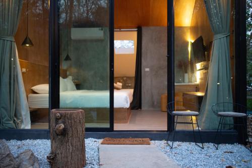 a glass house with a bedroom and a bed at Issara Bar&House in Ko Larn
