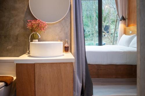 a bathroom with a sink and a bed and a mirror at Issara Bar&House in Ko Larn