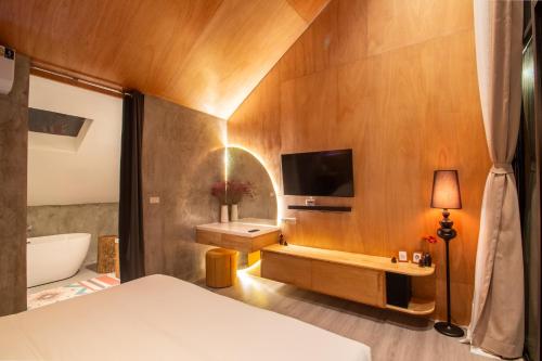 a bedroom with a bed and a tv on the wall at Issara Bar&House in Ko Larn
