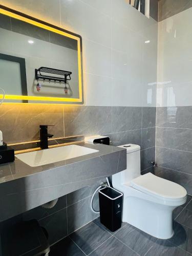 a bathroom with a toilet and a sink and a mirror at Khách Sạn Bình Minh-Đảo Phú Quý in Cu Lao Thu