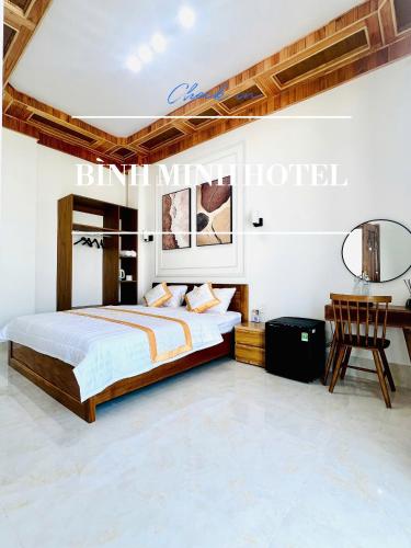 a bedroom with a bed and a table and a chair at Khách Sạn Bình Minh-Đảo Phú Quý in Cu Lao Thu