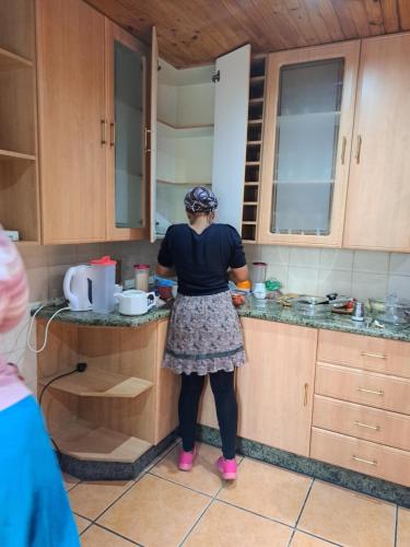 a woman standing in a kitchen preparing food at Gae la boroko in Brakpan
