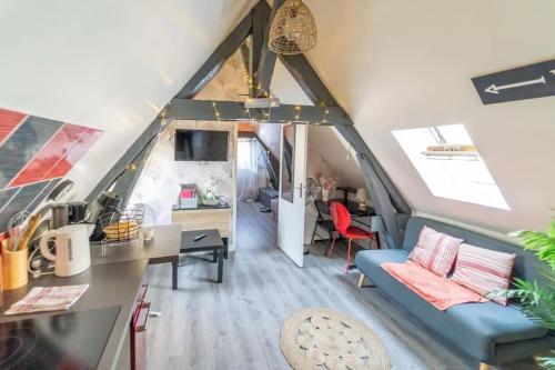 un salon avec un canapé bleu et une table dans l'établissement L'ETOILE DE BLOIS Appart Hyper Centre Château Gare à 5min, à Blois