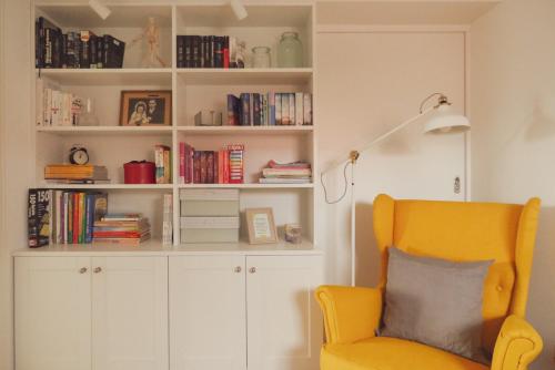 a living room with a yellow chair and a book shelf at Haus Hummel Ferienwohnung Liese in Lieske