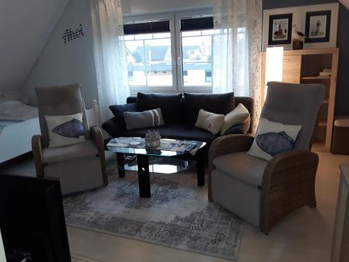 a living room with a couch and two chairs and a table at Ferienwohnung Nordlicht in Nortorf