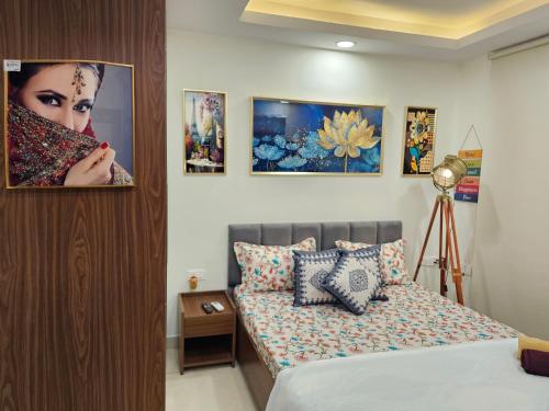 a bedroom with a bed and some pictures on the wall at Ultra Luxury 1Bhk 1121 Flat By Bliss Stay in Ghaggar