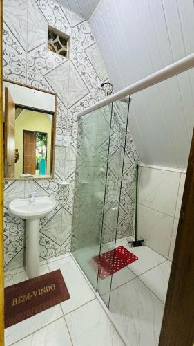 a bathroom with a shower and a sink at Chalé das hortênsias in Bonito