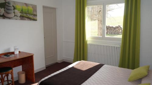 a bedroom with a bed and a window with green curtains at Hôtel Robinson in Auch
