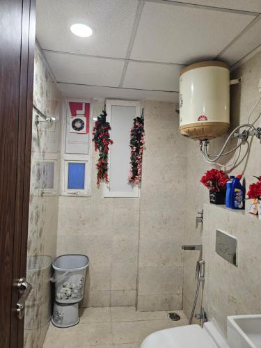 a bathroom with a toilet and christmas decorations on the wall at Ultra Luxury 1Bhk 1121 Flat By Bliss Stay in Ghaggar