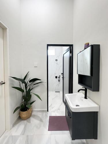 a bathroom with a tv and a sink and a mirror at Senja Homestay besut POOL in Jertih