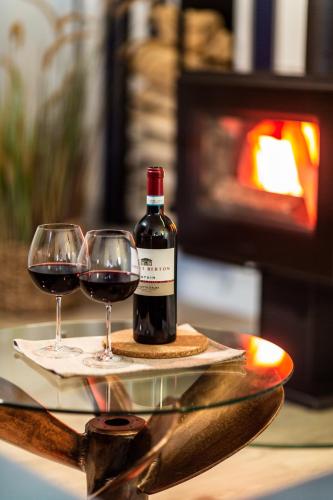 two glasses of red wine on a table with a fireplace at Osterhof Fehmarn - Casa Mare in Fehmarn