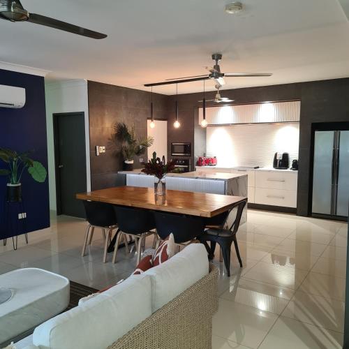 a kitchen and dining room with a table and chairs at 4 BDR Gardens Escape Inner City Townhouse with Secure Parking and Spa in Darwin