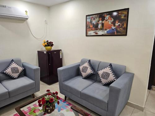 a living room with two couches and a painting on the wall at Ultra Luxury 1Bhk 1121 Flat By Bliss Stay in Ghaggar