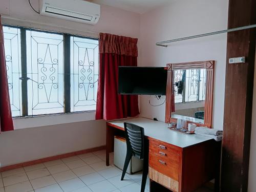 a room with a desk and a tv and window at New Budget Inn Hotel in Cukai