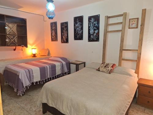 a bedroom with two beds and a ladder at Hotel Posada Spa Antigua Casa Hogar in Taxco de Alarcón