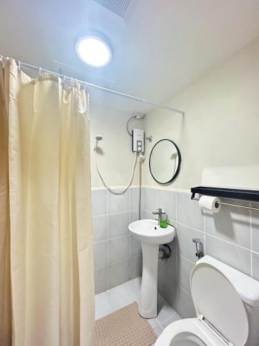 a bathroom with a shower and a toilet and a sink at CityView Near Airport with Pool&Balcony in Lapu Lapu City