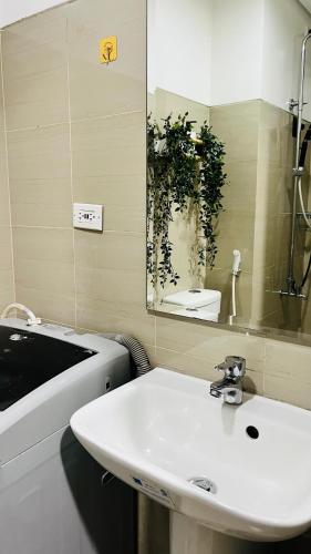 ein Badezimmer mit einem weißen Waschbecken und einem Spiegel in der Unterkunft GM staycations by Maria Direct Access to pool in Manila