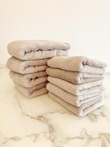 a stack of towels on top of a marble counter at Ushamy's KOKURA STAY No 03 in Kitakyushu