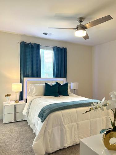 a bedroom with a white bed and blue curtains at Allstar Luxury Home LLC in Durham