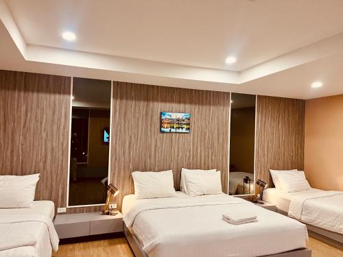 a hotel room with two beds and a mirror at USABAI Riverside Boutique Hotel in Chanthaburi