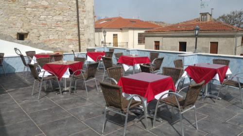 un grupo de mesas y sillas con cubiertas rojas en un patio en Bar Centrale Zichella, en Lacedonia