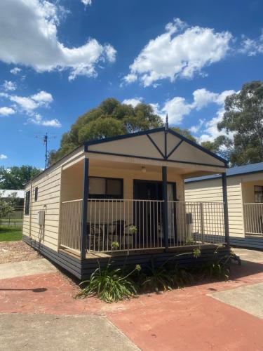 a mobile home with a porch and a fence at Young Caravan and Tourist Park in Young