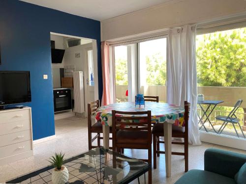 un salon avec une table, des chaises et une télévision dans l'établissement Appartement T2 confortable avec Wifi, loggia spacieuse, garage à Balaruc-les-Bains - FR-1-553-289, à Balaruc-les-Bains