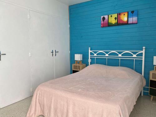 une chambre avec un mur bleu et un lit dans l'établissement Appartement T2 confortable avec Wifi, loggia spacieuse, garage à Balaruc-les-Bains - FR-1-553-289, à Balaruc-les-Bains