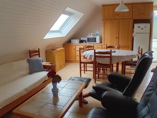 un salon avec un canapé et une table avec des chaises dans l'établissement Appartement 1er étage avec jardin et parking près de Le Palais - FR-1-418-263, au Palais