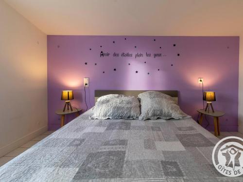 a bedroom with a large bed with a purple wall at Gîte Camomille à la campagne, proche du Puy du Fou - FR-1-622-99 in Saint-Georges-du-Puy-de-la-Garde