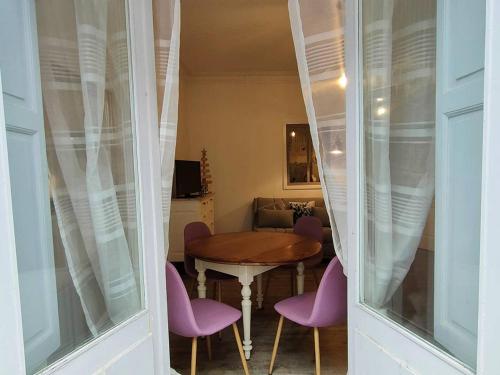 une salle à manger avec une table et des chaises violettes dans l'établissement Beau studio 4 pers, proche centre Cauterets - FR-1-234-334, à Cauterets