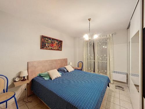 une chambre avec un lit avec une couette bleue dans l'établissement Appartement 3 pièces, terrasse ensoleillée, climatisation, stationnement, 4 pers - FR-1-475-155, à Saintes-Maries-de-la-Mer