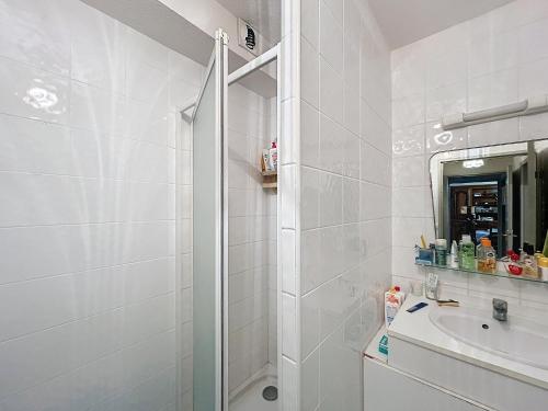 une salle de bain blanche avec une douche et un lavabo dans l'établissement Appartement 3 pièces, terrasse ensoleillée, climatisation, stationnement, 4 pers - FR-1-475-155, à Saintes-Maries-de-la-Mer