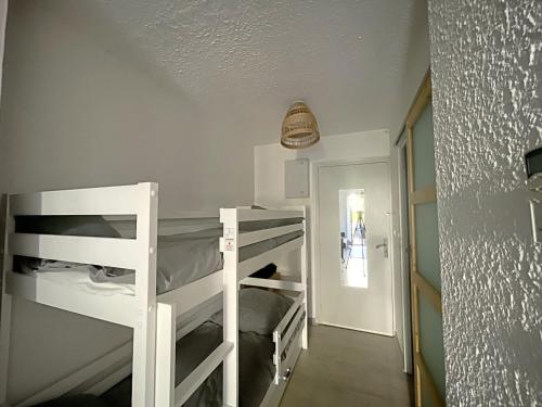 Cette chambre comprend 2 lits superposés et un couloir. dans l'établissement Studio 4 pers avec cour, Saintes-Maries-de-la-Mer - FR-1-475-200, à Saintes-Maries-de-la-Mer