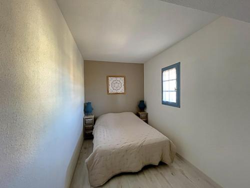 une petite chambre avec un lit et une fenêtre dans l'établissement Appartement 4 pers avec climatisation et parking privé à Saintes-Maries-de-la-Mer - FR-1-475-191, à Saintes-Maries-de-la-Mer